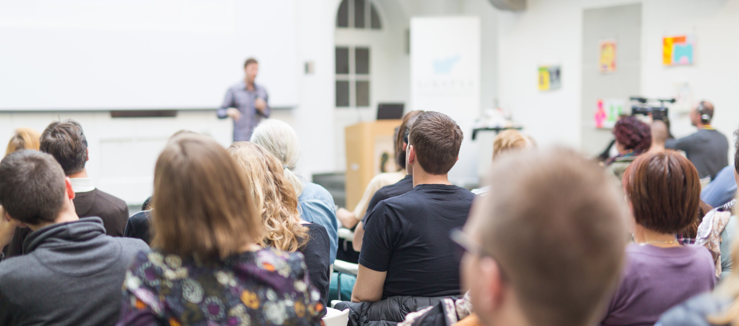 Male,Speaker,Giving,Presentation,In,Lecture,Hall,At,University,Workshop.